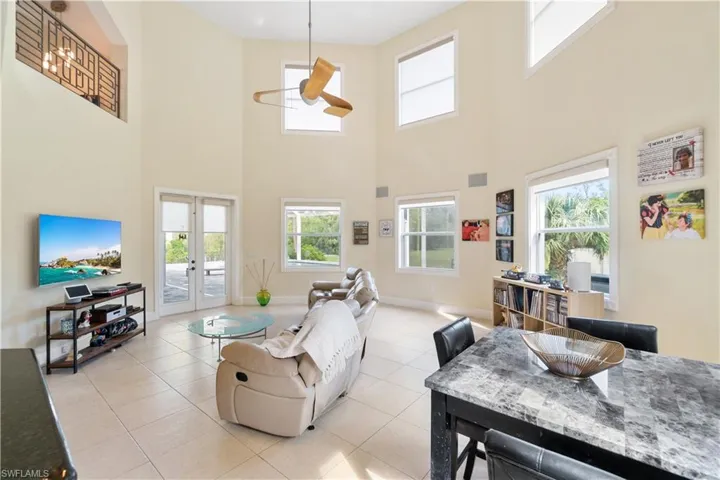 Living area with light tile patterned floors, french doors, visible vents, and baseboards