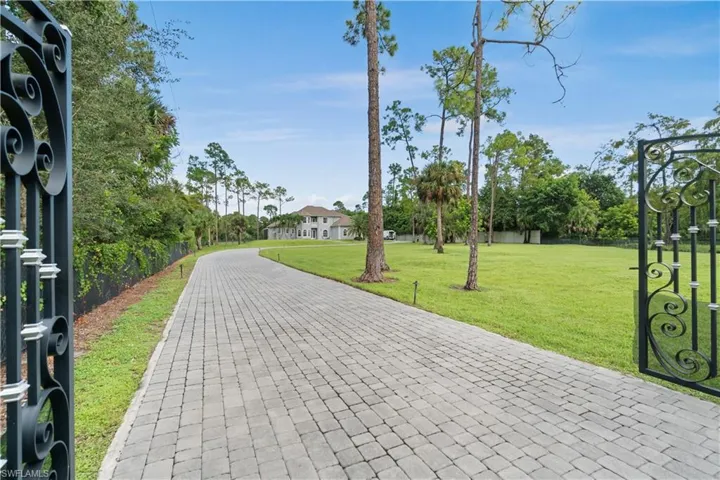 View of property's community with a lawn and fence