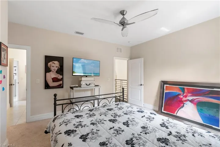 Bedroom featuring baseboards, ceiling fan, visible vents, and light colored carpet