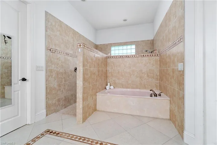 Bathroom with a walk in shower, a garden tub, and tile patterned floors