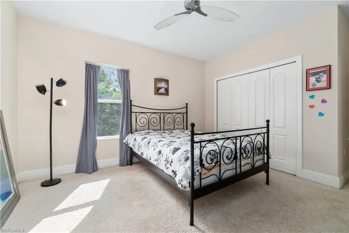 Bedroom featuring a ceiling fan, carpet, baseboards, and a closet