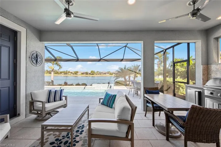 The lanai overlooks the pool and lake and has a POOL BATH, OUTDOOR KITCHEN (September 2021), 2 ceiling fans (August 2021), recessed lighting and Storm Smart ELECTRIC HURRICANE SCREENS (August 2021).