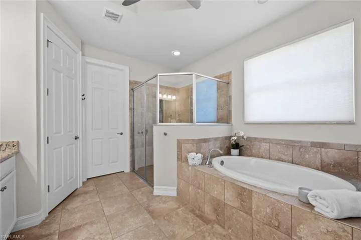 The large tile shower has a new DETACHABLE MAGNETIC SHOWER HEAD (February 2023), as well as the soaking tub. TRAY CEILING with ceiling fan/light (November 2020), tile floor, AUTOMATED WINDOW BLIND with remote (August 2017), private water closet, and large walk-in closet.