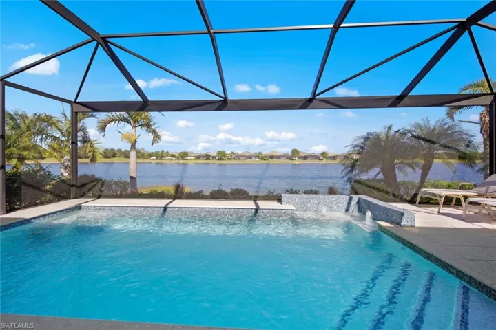 New Suncoast CUSTOM HEATED SALTWATER POOL with NO-SEE-UM PICTURE WINDOW SCREEN cage, bubbler feature, auto-fill, multi-colored lights, and Shellock ivory pavers (August 2021) providing views of the water.