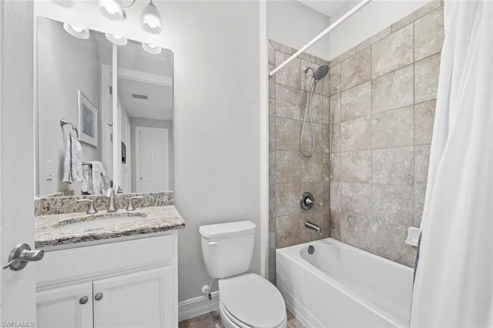 Located just outside bedroom 4 and across from the den is an additional full bath with tile floor, comfort height vanity with granite countertop, shower/tub with tile wall surround, and new DETACHABLE MAGNETIC SHOWER HEAD (February 2023).