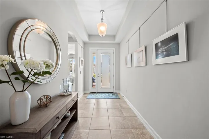 Large entry with tile floor, tray ceilings,  and "modern design" IMPACT GLASS front door and side light (July 2021). The home has an Xfinity alarm system (April 2017).