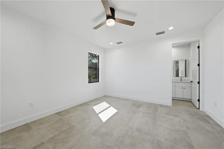 Unfurnished bedroom with ceiling fan, recessed lighting, and connected bathroom