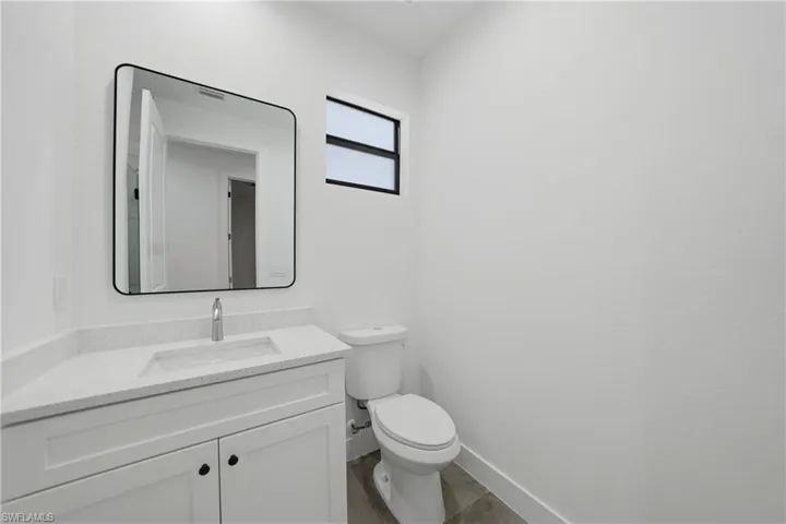 Half bathroom with vanity and toilet