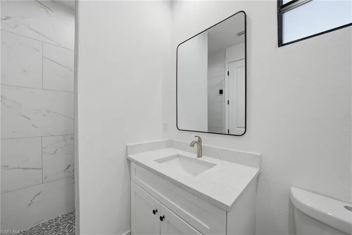 Full bath with vanity and a marble finish shower