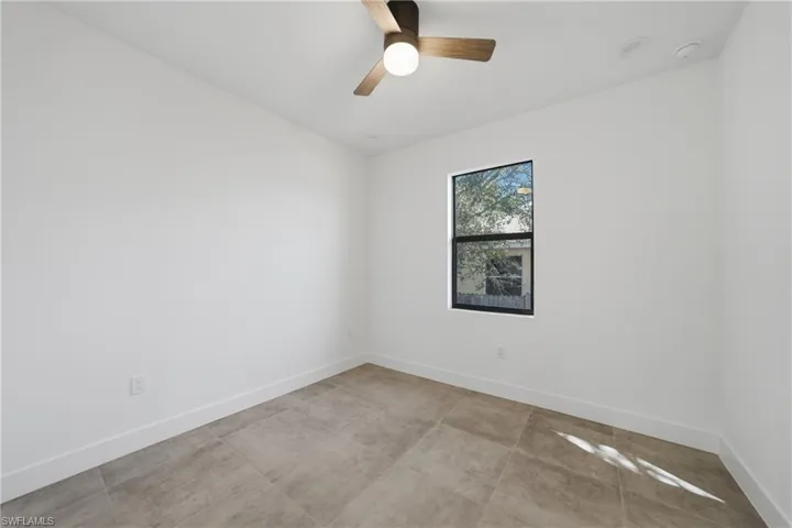 Empty room with baseboards and a ceiling fan