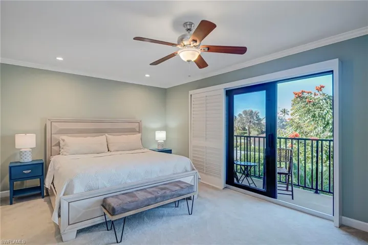 Primary Bedroom featuring ornamental molding, light colored carpet, access to exterior, a ceiling fan, and recessed lighting. Impact sliding doors with accordian plantation shutters with terrace balcony to enjoy sunsets and views. Gorgeous landscapes to look at and enjoy in the morning and at night!