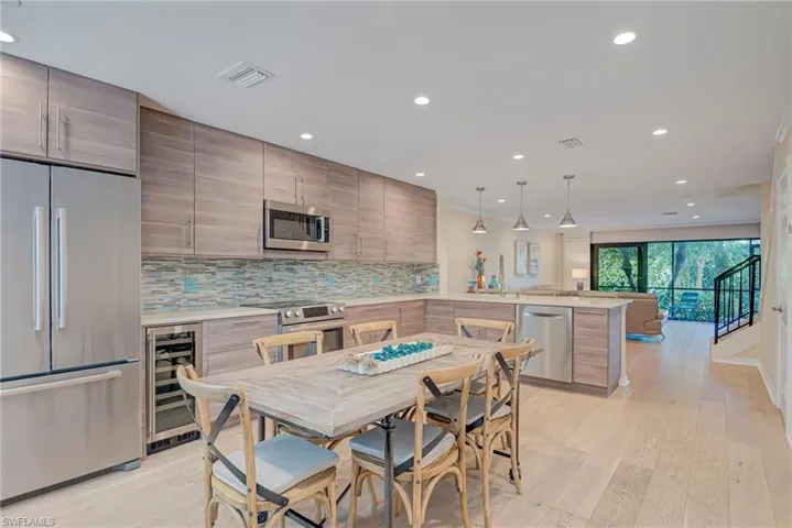 Kitchen featuring stainless steel appliances, light wood-type flooring, pendant lighting, and modern cabinets.