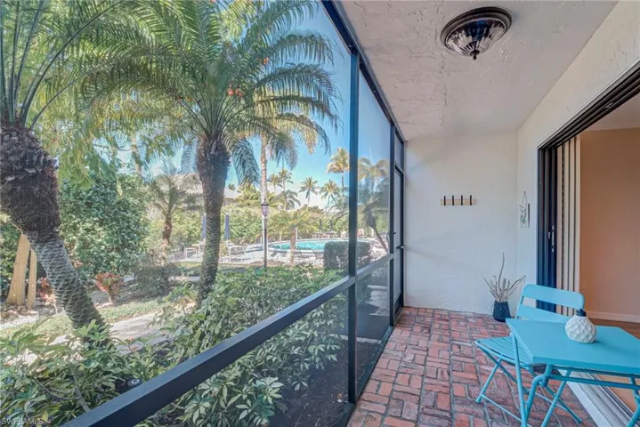 Screened-in patio lanai space with access to the pathway to the pool, carport, guest parking. Towel holder, 2 bike hooks, and a fan compliment this space.