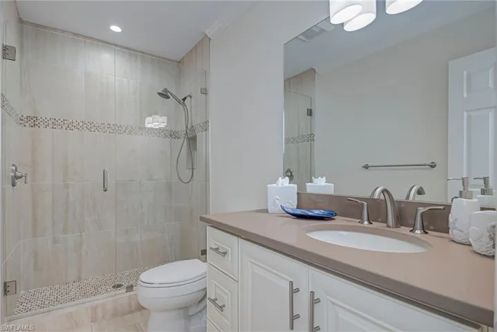 This is the bathroom in the hallway when you come up the stairs. Completly updated and neutral. Bathroom with vanity, a shower stall, and recessed lighting