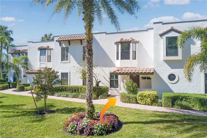 Mediterranean style - featuring a front manicured yard, covered entry with a tiled roof, and stucco siding