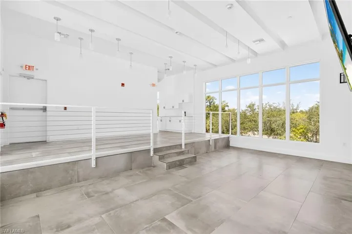 Unfurnished sunroom featuring beam ceiling