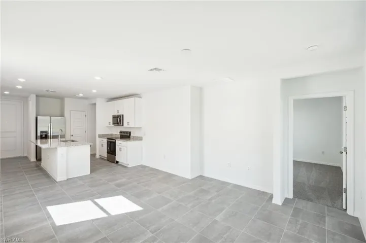 living room featuring sink and light tile patterned floors