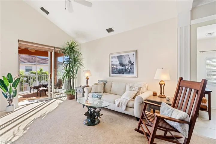 Living room featuring ceiling fan, light tile patterned floors, a healthy amount of sunlight, and high vaulted ceiling