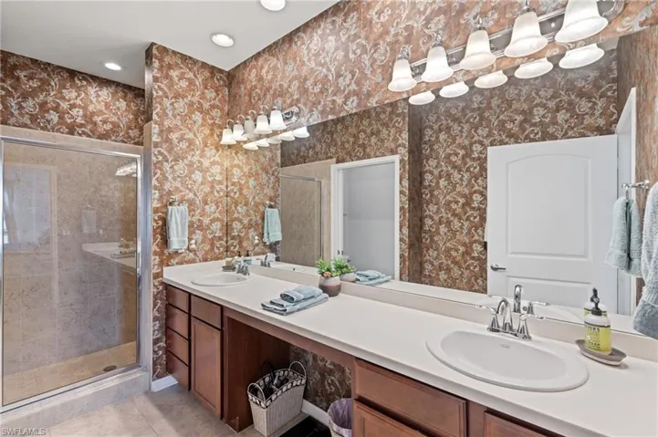 Bathroom featuring vanity, tile patterned floors, and a shower with door