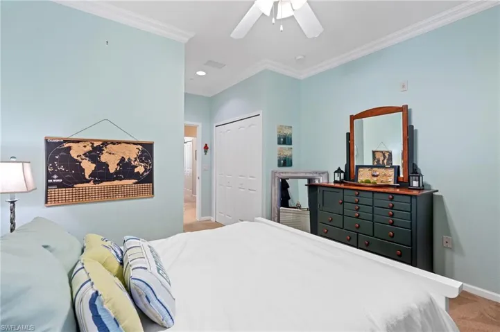Bedroom with carpet flooring, ceiling fan, ornamental molding, and a closet