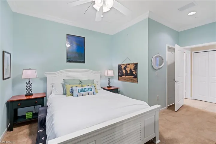 Carpeted bedroom featuring a closet, ceiling fan, and ornamental molding