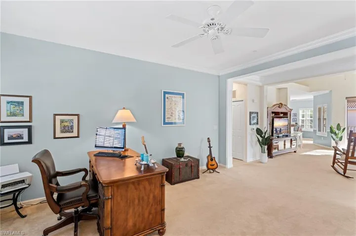 Office space with ceiling fan, ornamental molding, and light carpet