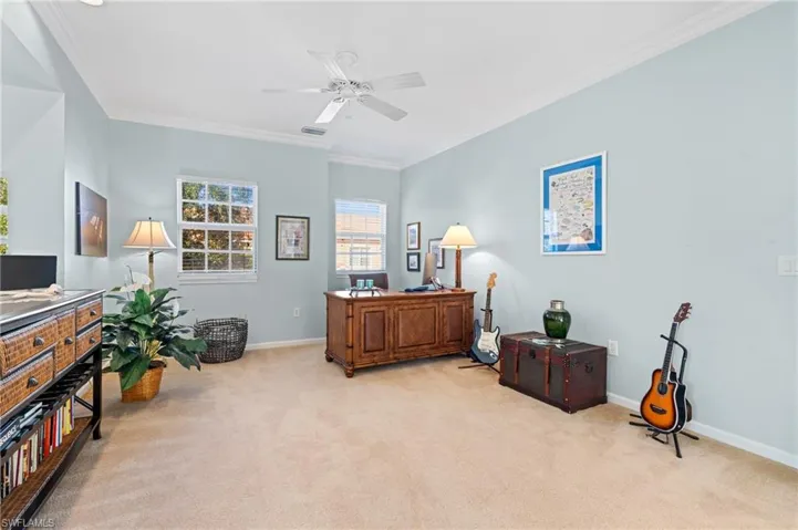 Office area featuring ceiling fan, crown molding, and light carpet