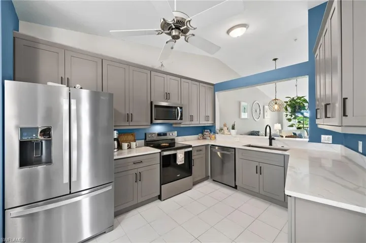 Kitchen featuring appliances with stainless steel finishes, sink, hanging light fixtures, and gray cabinets