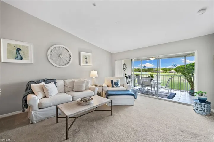 Living room featuring vaulted ceiling and carpet flooring