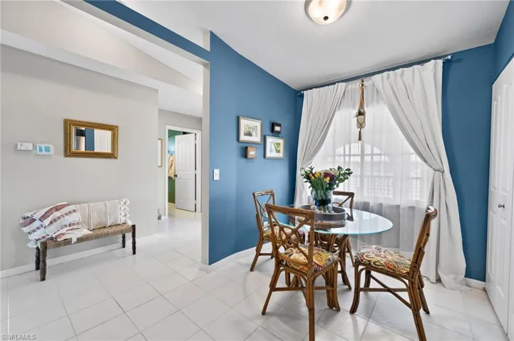 Dining space with vaulted ceiling and light tile flooring
