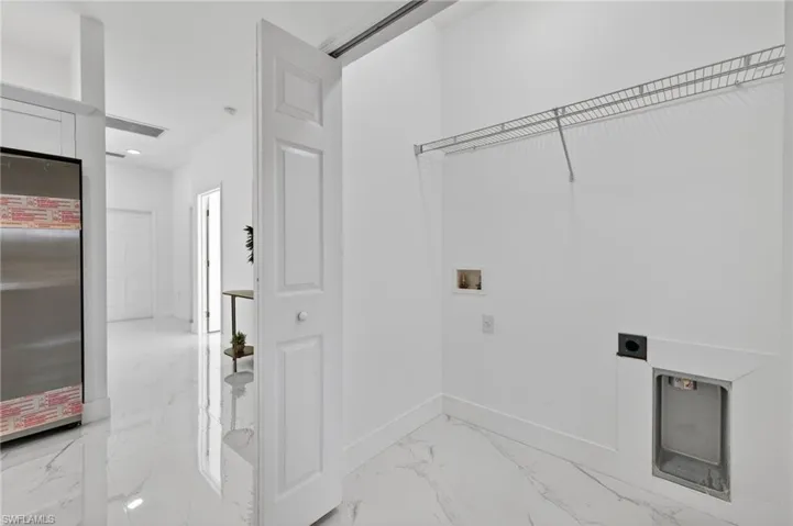 Laundry room with light marble finish flooring, washer hookup, and electric dryer hookup