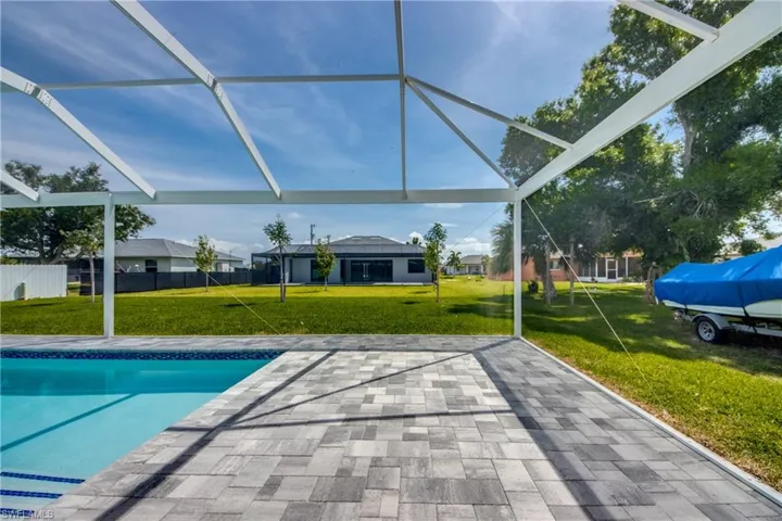 View of pool with a patio area and a lawn
