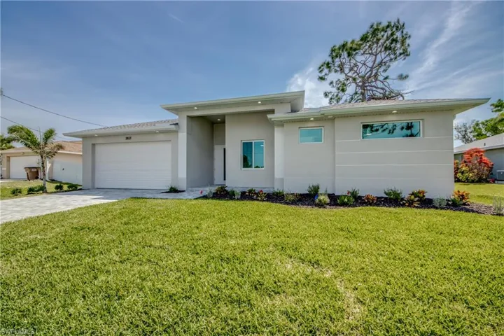 View of front of home with a front yard and a garage