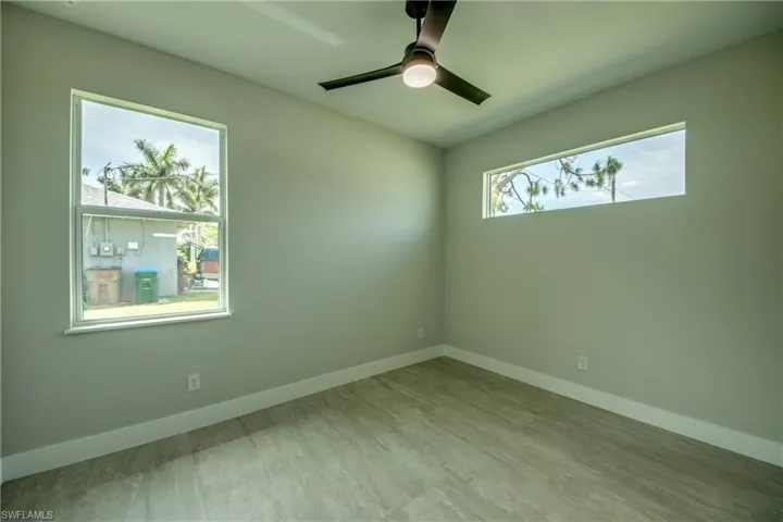 Spare room featuring ceiling fan, a healthy amount of sunlight, and light hardwood / wood-style floors
