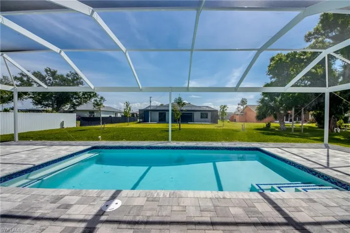 View of swimming pool with a lanai and a yard