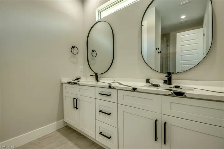 Bathroom featuring dual vanity and wood-type flooring