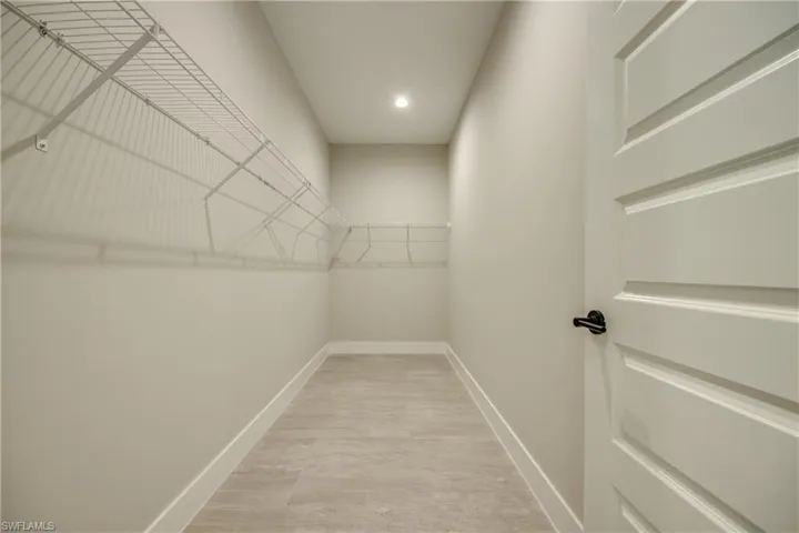 Walk in closet with light wood-type flooring