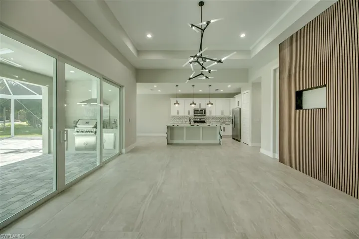 Unfurnished living room with a raised ceiling and light tile patterned floors