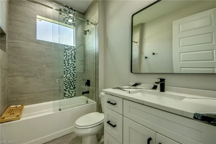 Full bathroom featuring toilet, vanity, and tiled shower / bath