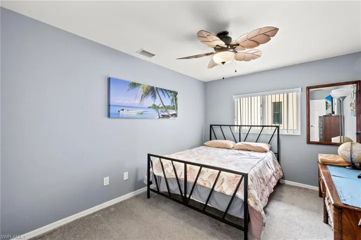 Carpeted bedroom featuring ceiling fan