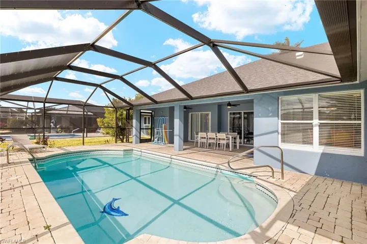 View of pool with ceiling fan, a patio area, and glass enclosure