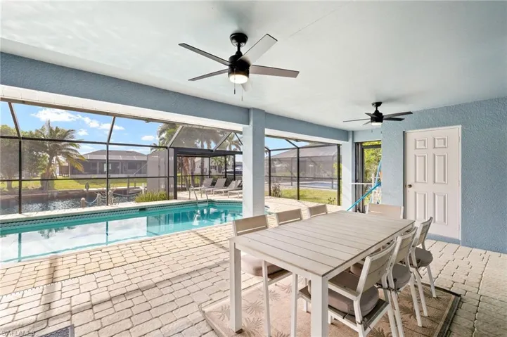 View of pool featuring a lanai, ceiling fan, and a patio
