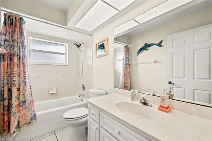 Full bathroom with toilet, vanity, tile patterned flooring, and shower / bath combo