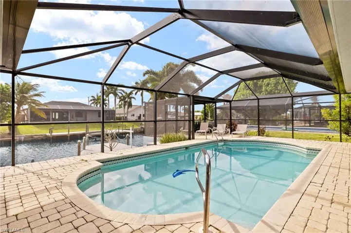 View of swimming pool with a lanai, a dock, and a patio