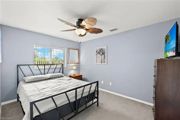 Carpeted bedroom with ceiling fan