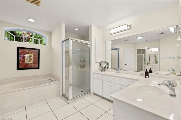 Bathroom with vanity, separate shower and tub, and tile patterned flooring