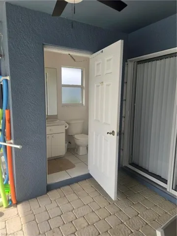 Pool Bath featuring toilet, vanity, tile patterned flooring, and ceiling fan