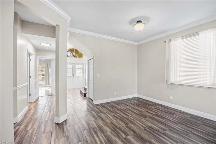 Spare room featuring ornamental molding and wood tiled floors