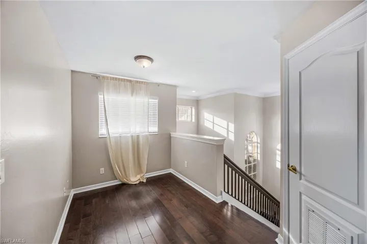 Unfurnished room featuring dark wood finished floors and ornamental molding