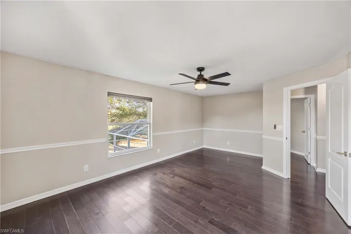 Unfurnished room featuring ceiling fan and dark wood finished floors